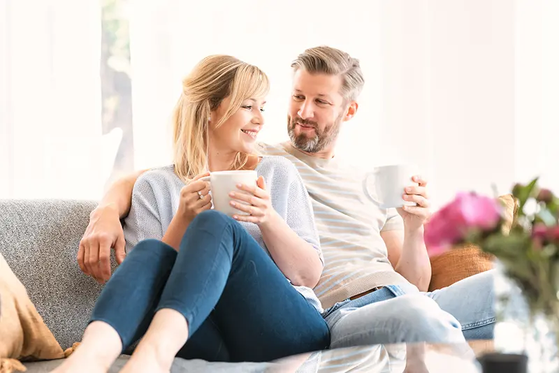 Couple on couch with coffee or tea